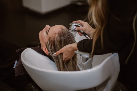 Shampoo anticaída aplicado sobre el cuero cabelludo y masajeado con las yemas